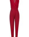 A contemporary-chic choice guaranteed to make an impact, Rachel Zoes rich red jumpsuit radiates modern glamour - Shawl lapel, sleeveless, button closure at waist, elasticized waistband, side slit pockets, pleated front, tapered legs, belted waistline, sheer back - Softly tailored fit - Wear with a fur coat and heels
